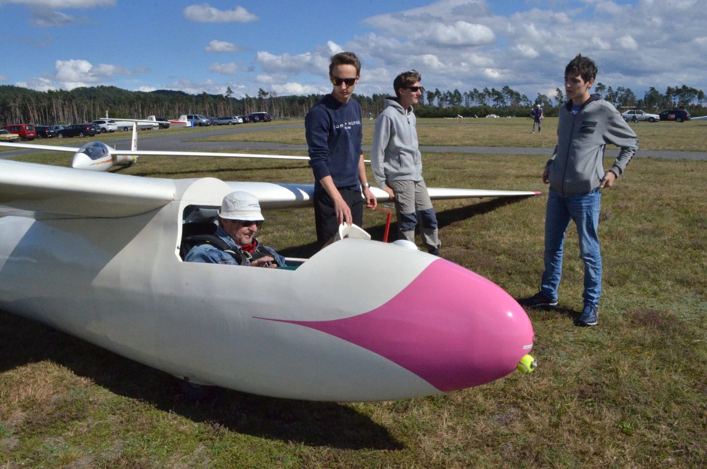 Jugendliche der Schülerfluggemeinschaft an einem Segelflugzeug auf dem Flugplatz